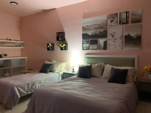 two beds in a room with pink walls at KRCB Suite - Evo Mall Bandar Baru Bangi in Kampong Sungai Ramal Dalam