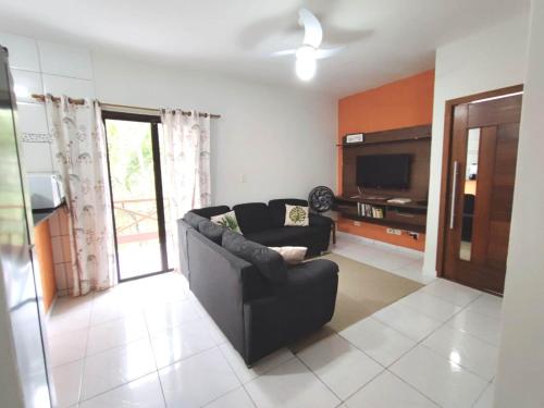 sala de estar con sofá y TV en Apartamento em Ilha bela, en Ilhabela