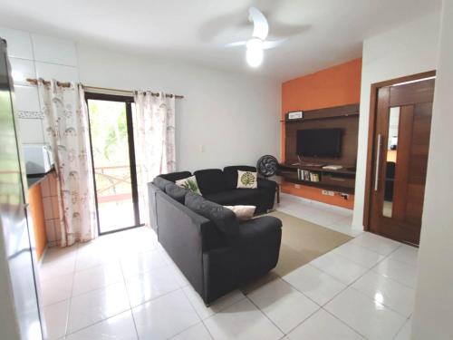 a living room with a couch and a tv at Apartamento em Ilha bela in Ilhabela