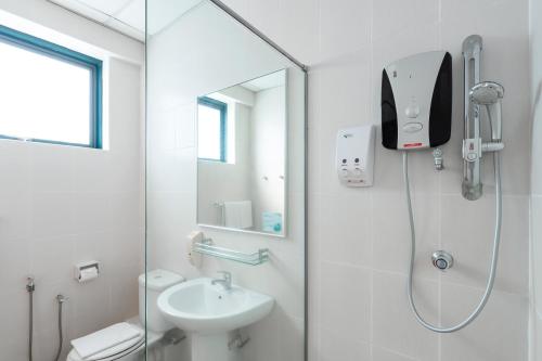 a white bathroom with a shower and a sink at Golden View Serviced Apartments in George Town