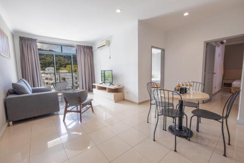 a living room with a couch and a table and chairs at Golden View Serviced Apartments in George Town