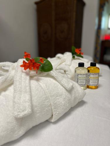 two bottles of essential oils and towels on a bed at Azure Del Mar in Maya Beach