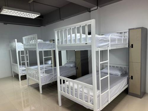 a room with three bunk beds in a room at PJ Hostel in Pak Chong