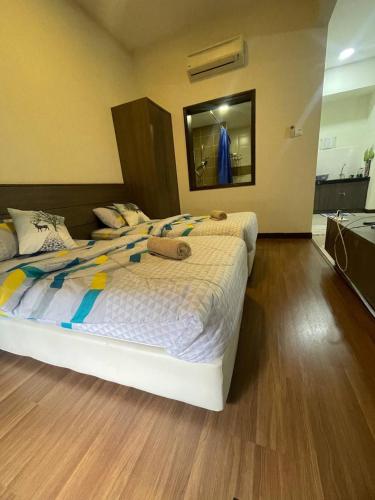 a bedroom with a large bed and a mirror at Junikastay BLagoon Melaka in Melaka