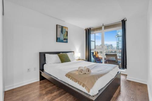 a bedroom with a large bed and a large window at Cityplace Luxury suites in Toronto