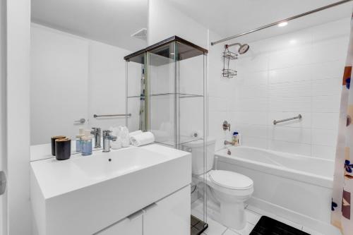 e bagno bianco con servizi igienici e vasca. di Cityplace Luxury suites a Toronto