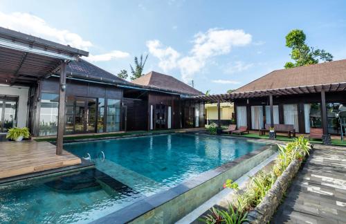 a swimming pool in front of a house at Shankara Munduk Bali in Munduk