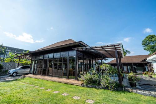 a house with glass windows and a yard at Shankara Munduk Bali in Munduk