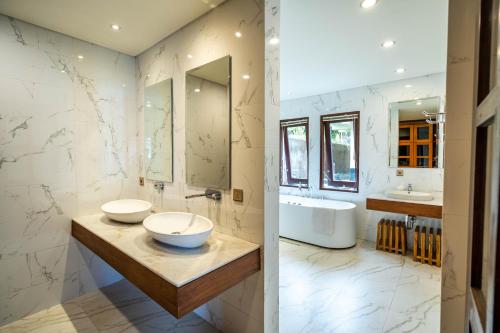a bathroom with two sinks and a tub at Shankara Munduk Bali in Munduk