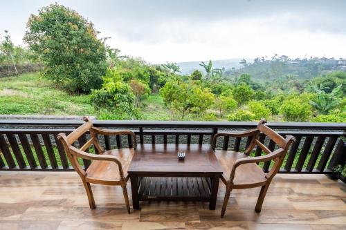a table and two chairs on a balcony with a view at Shankara Munduk Bali in Munduk