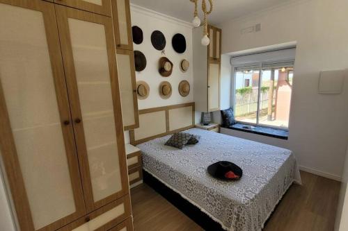 een slaapkamer met een bed met een hoed erop bij Refúgio Bicho do Mar in Passo de Torres