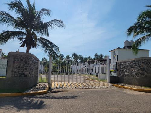 une porte avec un palmier en face d'un bâtiment dans l'établissement Casa de las Palmas, à Zihuatanejo