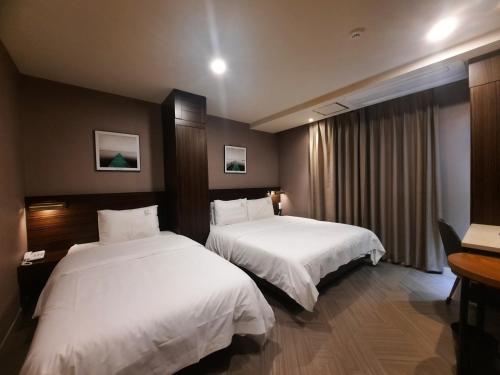 Un pat sau paturi într-o cameră la H Moment Hotel