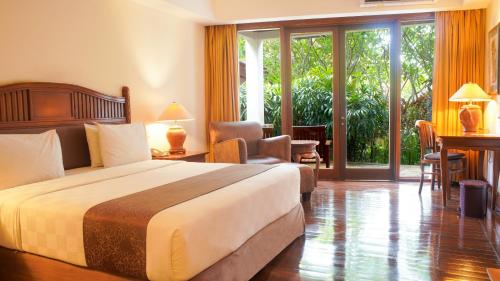 a hotel room with a bed and a large window at Lorin Solo Hotel in Solo
