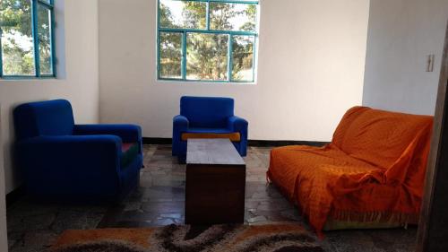 a living room with two chairs and a couch at Sauka Casa de campo in Villa de Leyva