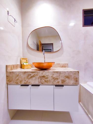 a bathroom with a wooden sink and a mirror at POUSADA E RESTAURANTE GAROUPA in São Miguel dos Milagres