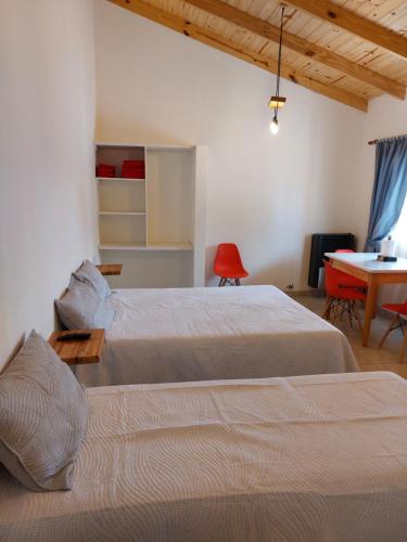 プエルト・サン・フリアンにあるG&D Departamentosのベッドルーム1室(ベッド2台、テーブル、テーブル付)