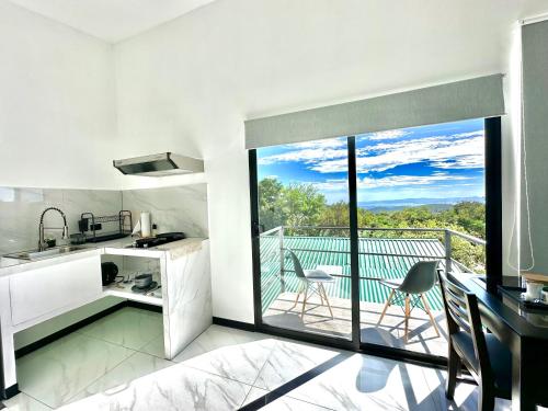 a kitchen with a view of a balcony at Black & White Apartments in Monteverde Costa Rica