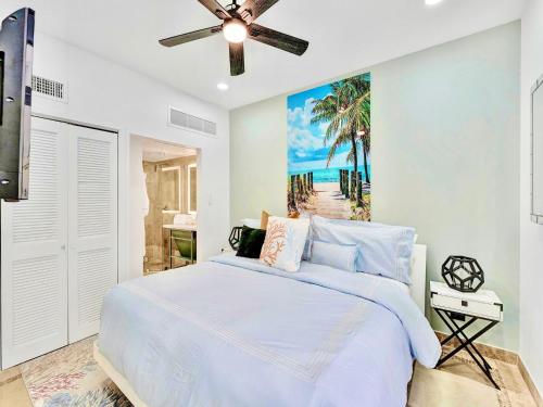 een slaapkamer met een bed en een schilderij van een strand bij Park Place South of Fifth in Miami Beach