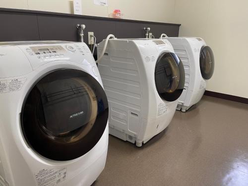 two washing machines sitting next to each other in a room at Misato Town Community Lodge Wakuasu in Daisen