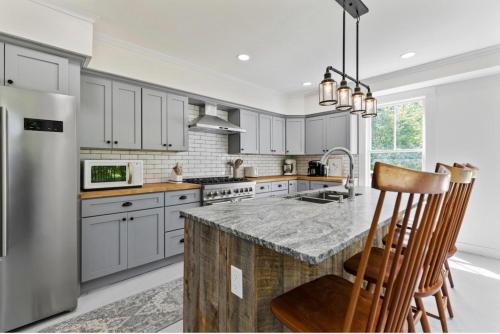 a kitchen with white cabinets and a granite counter top at The Blueberry House - Spacious, Family & Pet-Friendly Retreat near Sebago Lake in North Sebago