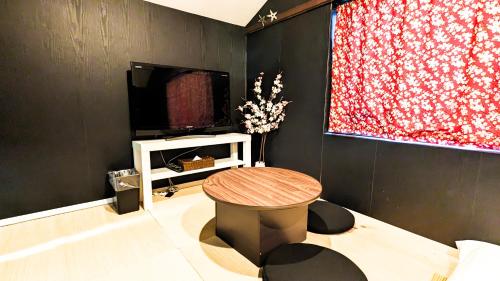 a living room with a table and a tv at USJ 2 stops, Umeda&Dotonbori 8mins, Ninja Style SV1 in Osaka
