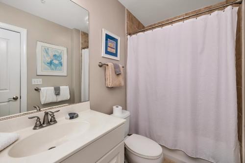 a bathroom with a sink and a toilet and a shower at Marina Retreat in Saint Simons Island