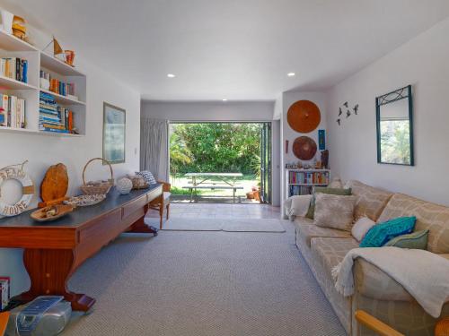 a living room with a couch and a table at Chucks Retreat - Opito Bay Holiday Home in Whitianga