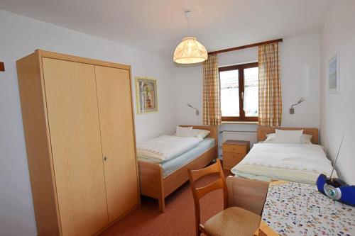 1 Schlafzimmer mit 2 Betten, einem Tisch und einem Stuhl in der Unterkunft Ferienwohnung Panorama im Gästehaus Bergfrieden in Bayersoien