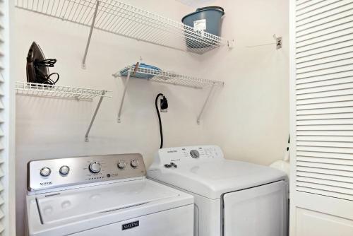 a white laundry room with a washer and dryer at The Pink House in Saint Simons Island