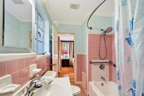a pink bathroom with a sink and a shower at The Pink House in Saint Simons Island