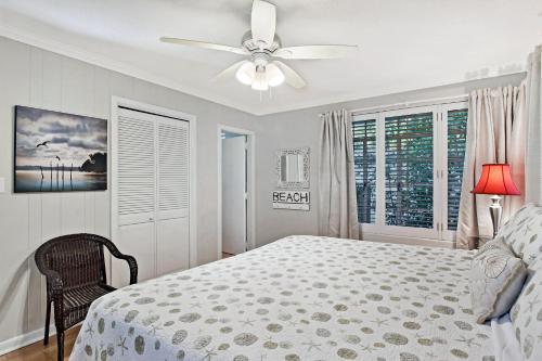 a white bedroom with a bed and a ceiling fan at The Pink House in Saint Simons Island