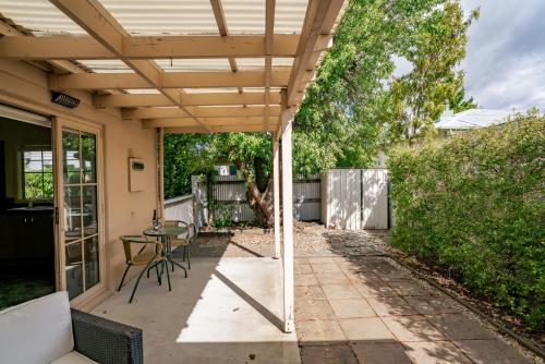 a patio with a table and a wooden pergola at Green Oasis - Cromwell Holiday Home in Cromwell