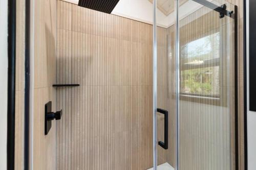a shower with a glass door in a bathroom at Cuyuna Adventure Cabin: Solo Stove - On Bike Trail in Crosby