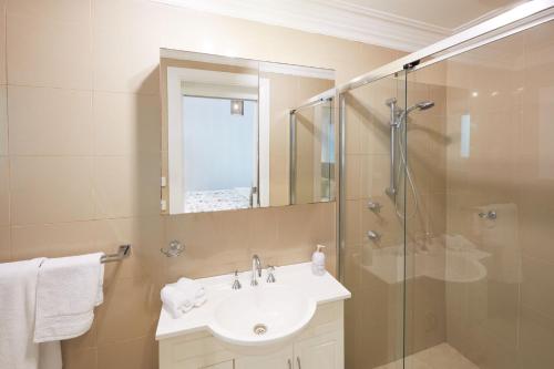 La salle de bains est pourvue d'un lavabo et d'une douche. dans l'établissement Beach Vibe at Terrigal- Stay FOR 3 PAY FOR 2, à Terrigal