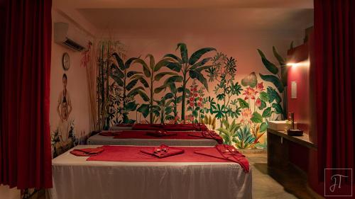 a bedroom with two beds with red sheets at Sala Baï Hotel & Restaurant School in Siem Reap