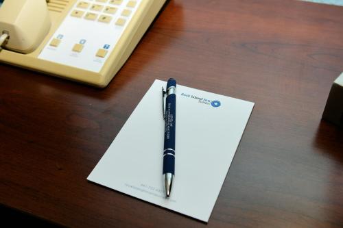 a pen sitting on top of a piece of paper on a desk at Rock Island Inn & Suites Marshalltown in Marshalltown
