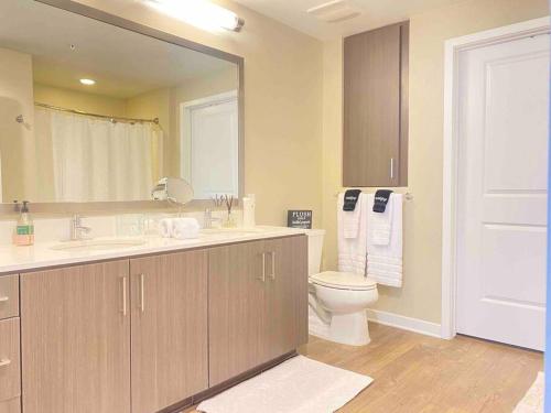 a bathroom with a sink and a toilet and a mirror at Lux Playa Vista 2 BDRM Condo in Los Angeles