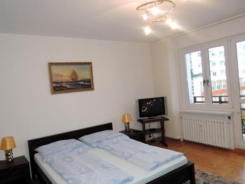 a bedroom with a bed and a television in it at Beautiful apartment with sea views in Miedzyzdroje in Międzyzdroje