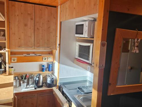 une petite cuisine avec un évier et un micro-ondes dans l'établissement Appartement duplex 4 pers à Arc 1800, balcon, Wi-Fi, accès pistes et commerces à proximité - FR-1-411-912, à Bourg-Saint-Maurice