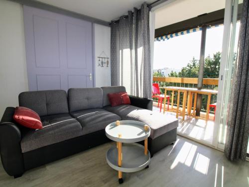 un salon avec un canapé et une table dans l'établissement Appartement T3 à Saint-Cyprien, Terrasses, Parking, 300m Plages - FR-1-309-414, à Saint-Cyprien