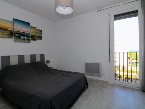 une chambre avec un lit et une grande fenêtre dans l'établissement Appartement T3 à Saint-Cyprien, Terrasses, Parking, 300m Plages - FR-1-309-414, à Saint-Cyprien