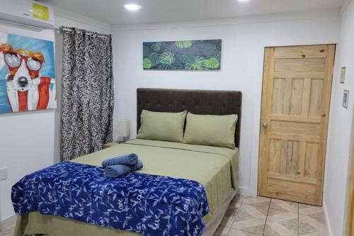 Un dormitorio con una cama con una almohada azul. en 1 Bedroom Apartment in center of town., en Utila