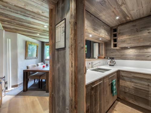 - une cuisine avec des murs en bois, une table et un évier dans l'établissement Duplex chaleureux au pied des pistes à Megève, 4 pers. - FR-1-569-84, à Megève