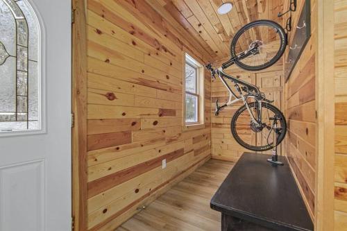 a bike hanging on the wall of a wooden cabin at Remodeled* Sleeps 7, Fire Pit, Indoor Bike Storage in Crosby