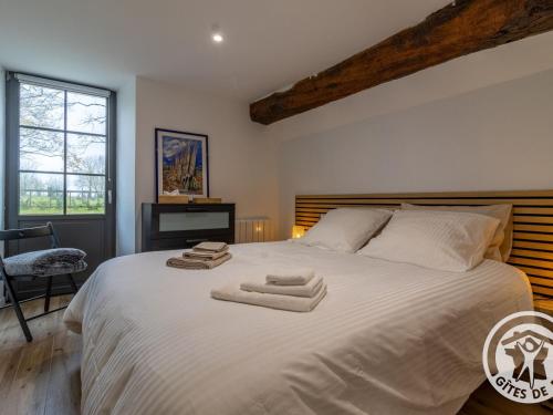 a bedroom with a large white bed with towels on it at Gîte charmant entre Loire et Layon, terrasse, jardin, parking, proche d'Angers, idéal pour couples - FR-1-622-71 in Rochefort-sur-Loire