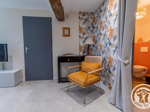 a yellow chair in a room with a desk at Gîte charmant entre Loire et Layon, terrasse, jardin, parking, proche d'Angers, idéal pour couples - FR-1-622-71 in Rochefort-sur-Loire
