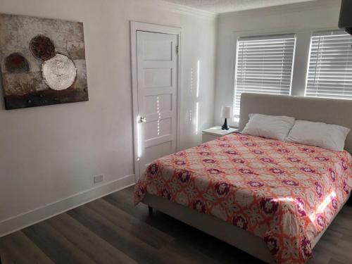 een slaapkamer met een bed met een rood dekbed bij Lovely 1B1B Home in Heart of Pasadena in Pasadena