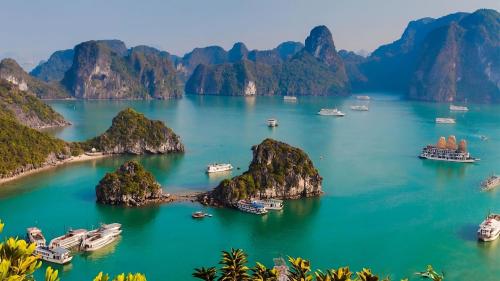 - une vue sur une baie avec des bateaux et des montagnes dans l'établissement Việt Hoàng Hotel Hạ Long, à Hạ Long