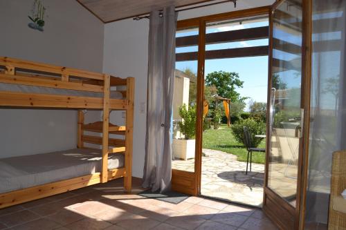 a bedroom with a bunk bed and a patio at Village de gîtes Les Olivettes in Saint-Dézéry